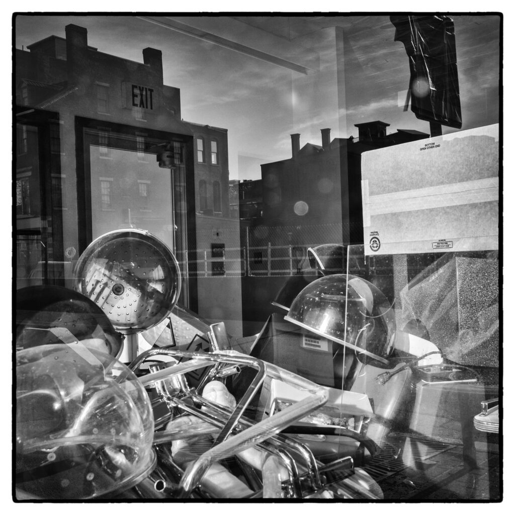 Looking through a window into a classroom. A pile of equipment sits in the foreground.
