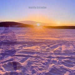 sunset in distance across snow with silouette