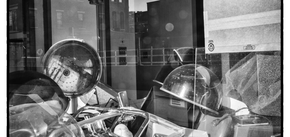 Looking through a window into a classroom. A pile of equipment sits in the foreground.