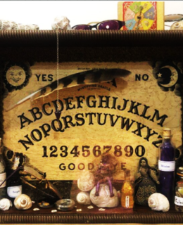 Shadow-box still life with Ouija board, artifacts, potions and shells