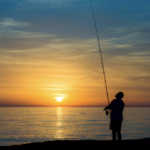 a man fishing at sunset