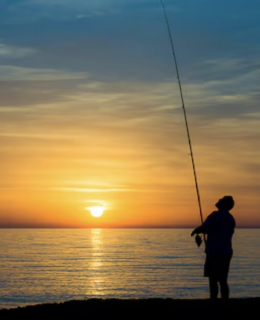 a man fishing at sunset