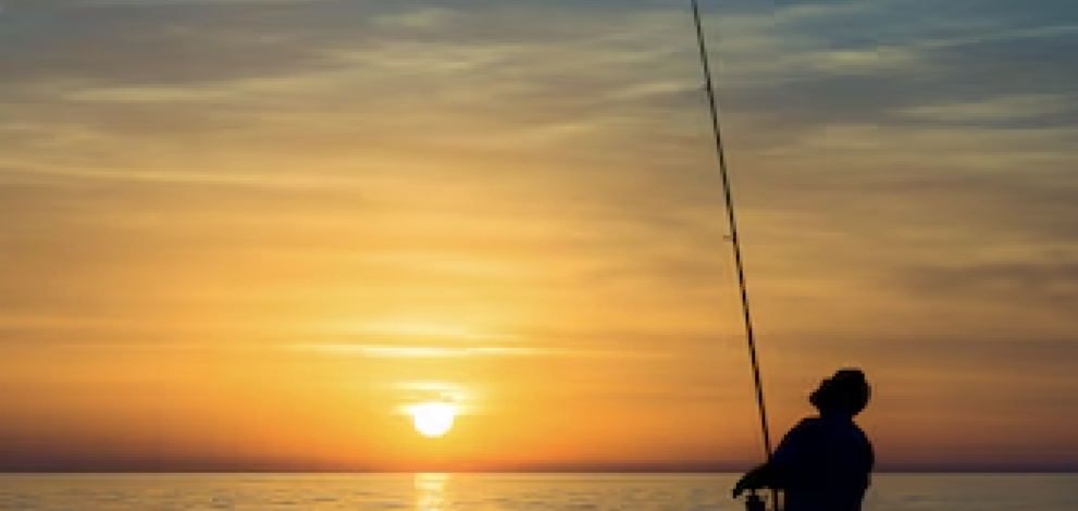 a man fishing at sunset