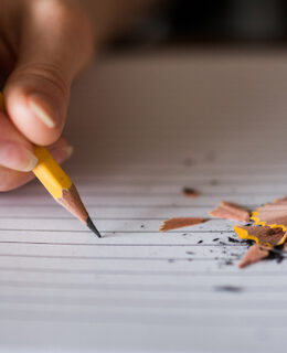a picture of someone writing with a pencil that is breaking