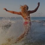 a woman in a bathing suit running into the ocean