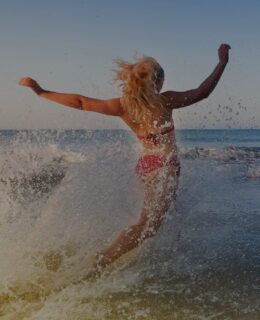 a woman in a bathing suit running into the ocean